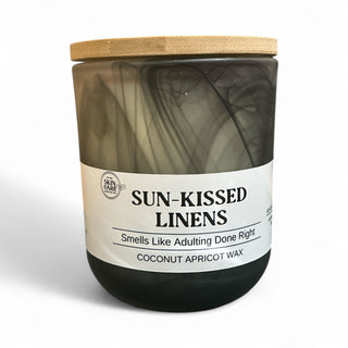 Eco-friendly hand-poured candles in marbled glass jars with bamboo lids by M&S Skin Care.