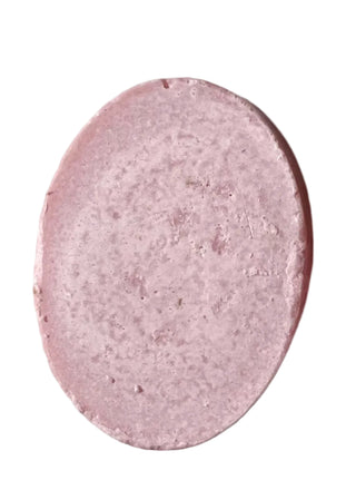 A pink Budding Romance Sea Salt and Clay Spa Bar with a textured, granular surface